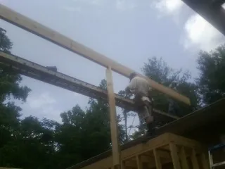 Carpenter setting a ridge beam over a new addition frame — Ice Dam Removal by Roofing Brothers in Arriba