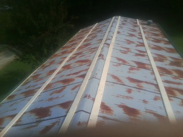 Rusted metal roof panels with new wood purlins before replacement — Storm Damage Roof Repair in Arriba by Roofing Brothers