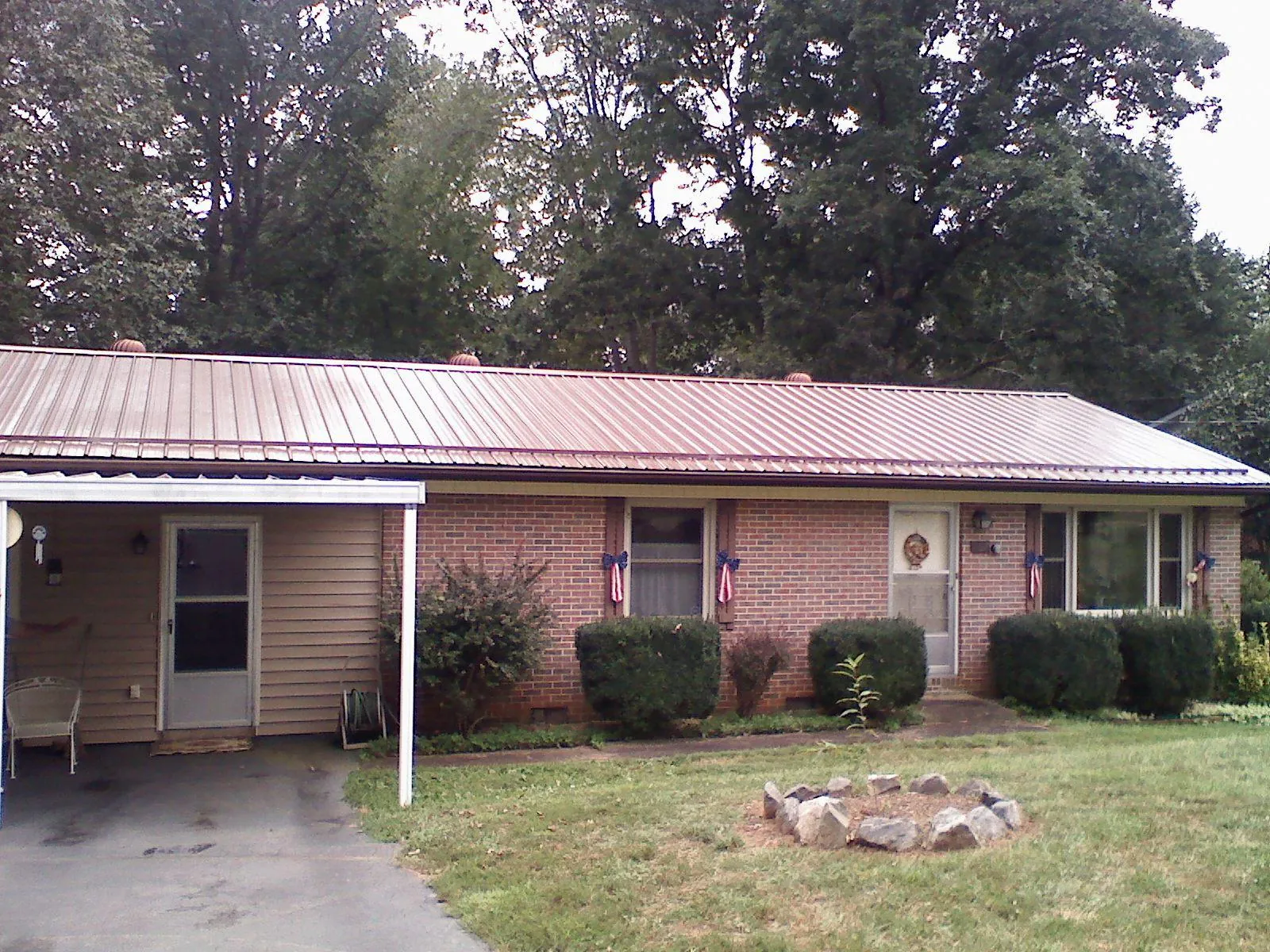 Bronze metal roof and carport on a brick ranch home — Roof Repair work by our crew in Arriba