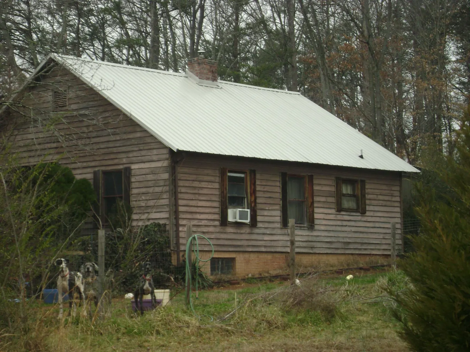 White metal roof on an old wood sided farmhouse, from a Metal Roof Installation job in Arriba